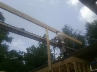 Carpenter setting a ridge beam over a new addition frame — Ice Dam Removal by Roofing Brothers in Lomax