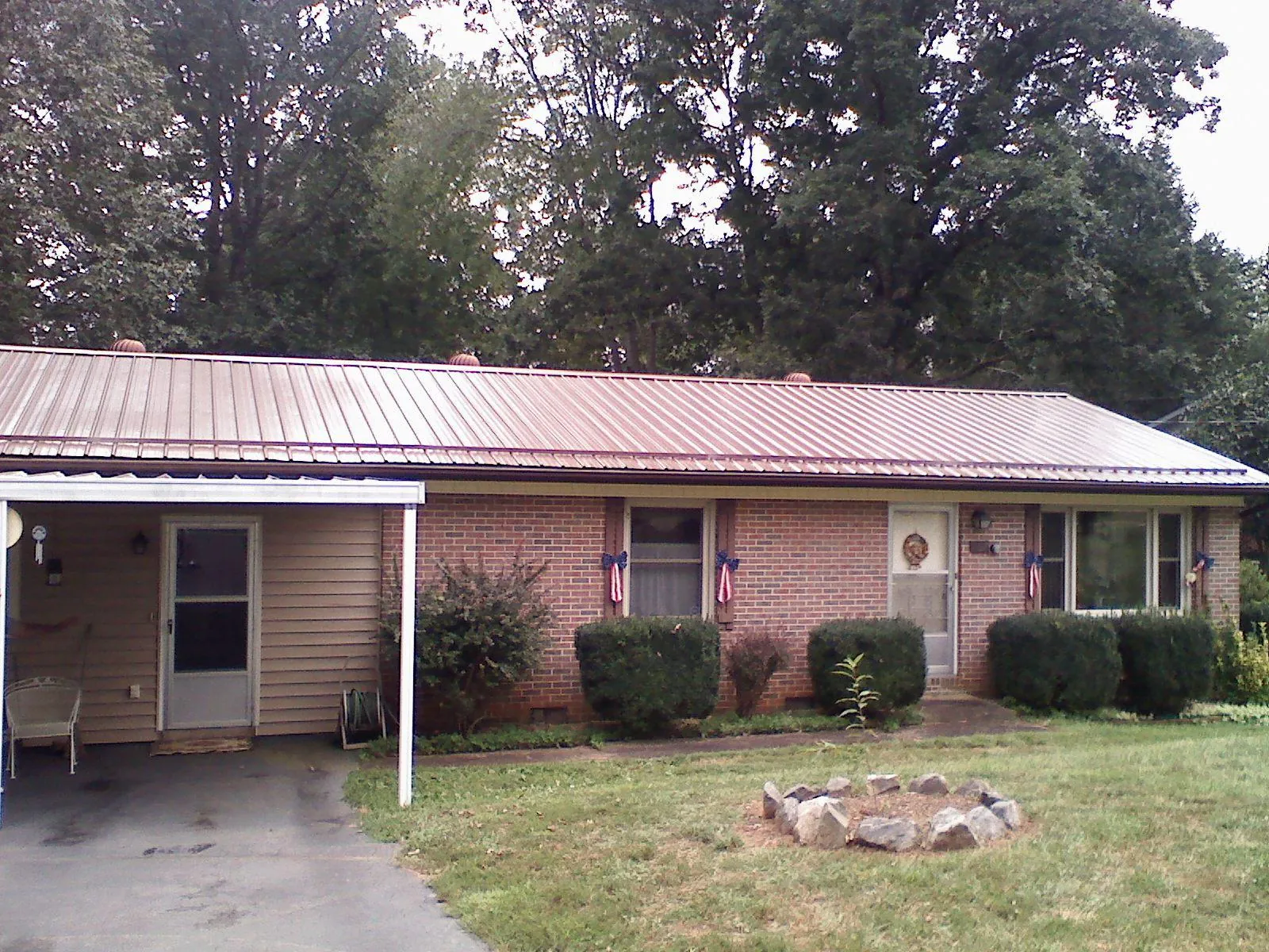 Bronze metal roof and carport on a brick ranch home — Roof Repair work by our crew in Lomax