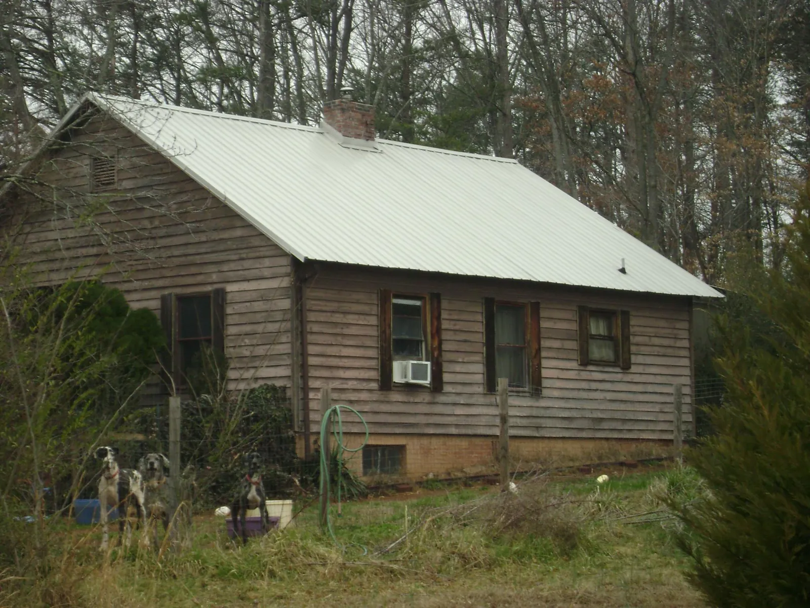 White metal roof on an old wood sided farmhouse, from a Metal Roof Installation job in Lomax